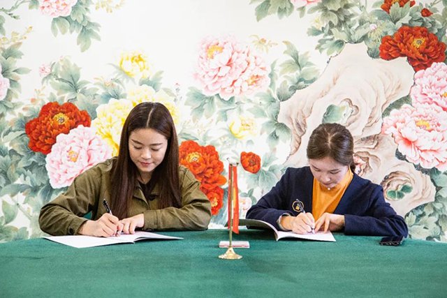 邱夏芳女士(左)与肖雪女士(右)共同签订合同